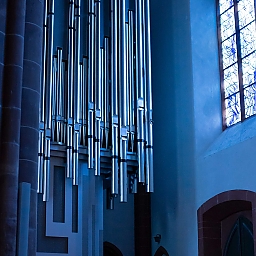 Klais-Orgel von St. Stephan – die silbernen Orgelpfeifen sind getaucht in ein kräftiges, blaues Licht durch das in Kobalt gehaltene Chagall-Fenster (süd-ost-Seite des Kirchenschiffs). 