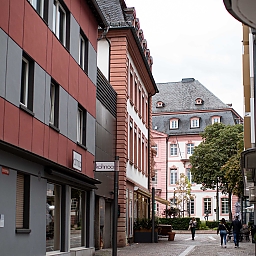 Nebenstraße in der Mainzer Innenstadt, Architektur-Mix aus Häusern aus dem 19./20. Jahrhundert und der Moderne, gepflasterter Weg für Fußgänger:innen.