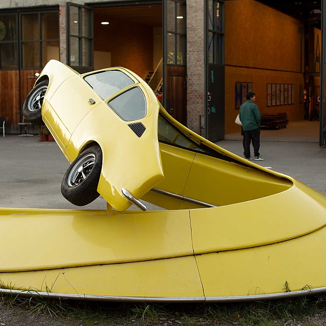 Skulptur in leuchtend Gelb: Künstlerisch zu einer Schnecke verformte Auto-Karosse