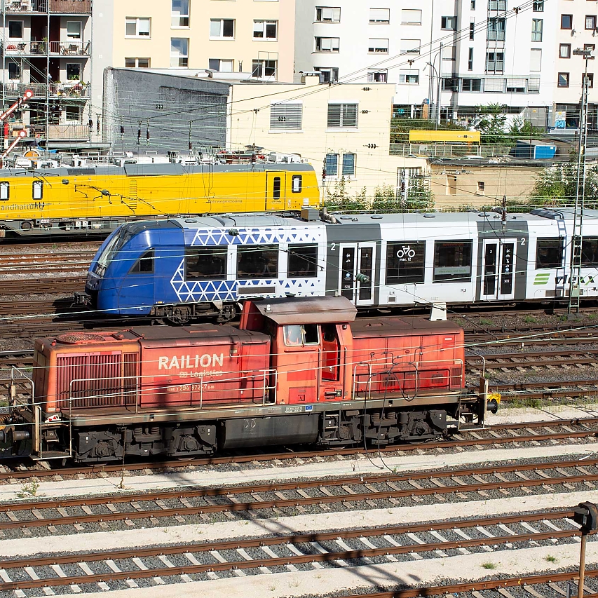 Blick aus dem B+B Hotel (5. Stock) auf das Gleisbett mit zwei Lokomotiven für Güterverkehr und Rangier-Verkehr sowie den Triebwagen eines Regionalzugs.