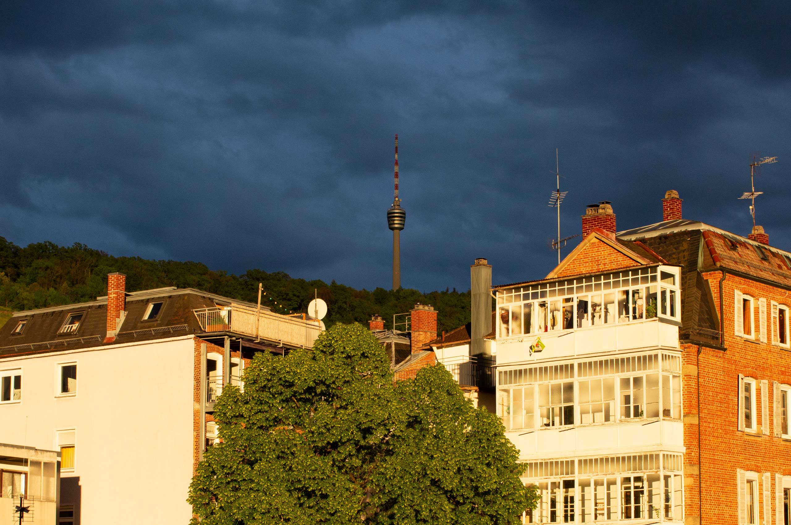 AUTOR: copy | TITLE: Bürofensterblicke: Dramatischer Sonnenuntergang über Stuttgart-Süd | DESCRIPTION: Kräftig dunkelblau-grauer Himmel (Kulisse) und golden angestrahlten Häusern (Vordergrund)
                        
