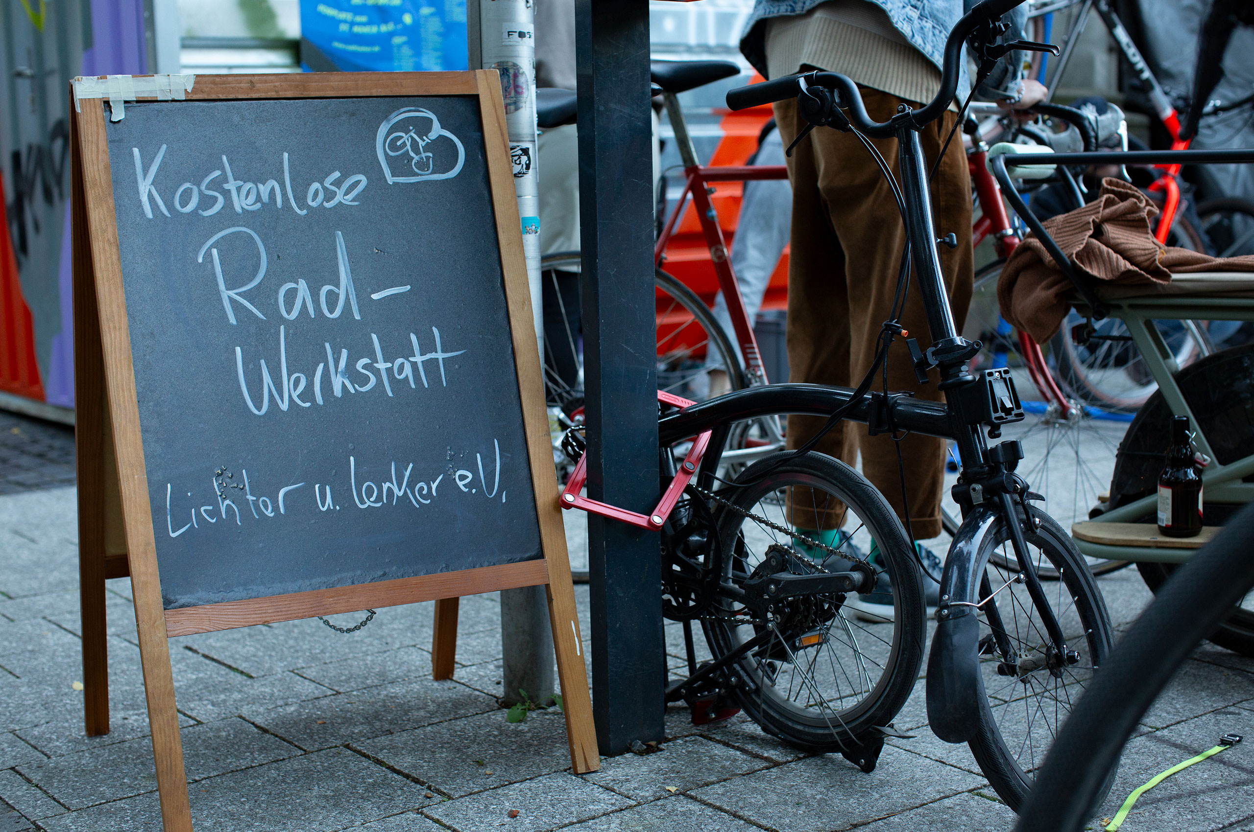 Verschiedene Fahrräder – von einem Bromten Falt-Rad über Lasten-Räder bis zu einem Renn-Rad. Daneben der Hinweis auf die Kostenlose Rad-Werkstatt von Lichter und Lenker e.V. im Rahmen des Festes. Bild: cc FAHRRADkultur c/o Franziska Köppe | madiko